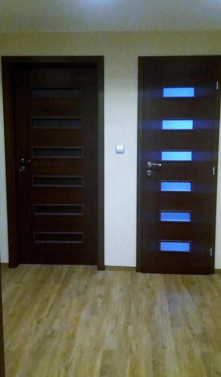 Dvoje tmavé interiérové dveře s prosklenými pruhy