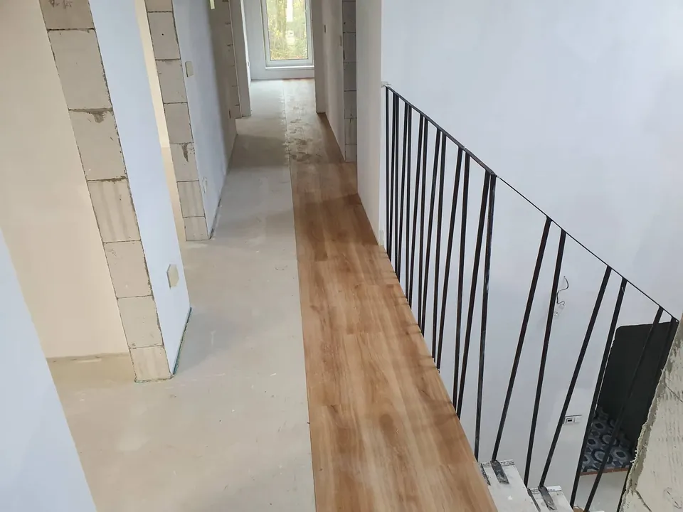Pokládka podlahy v chodbě podél zábradlí schodiště