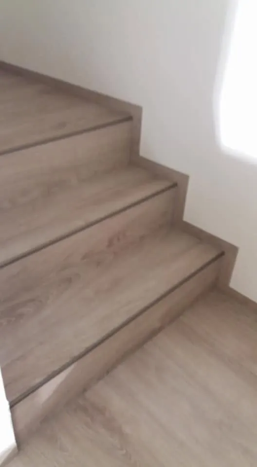 Schody v dekoru šedého dubu u bílé stěny
